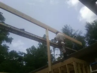 Carpenter setting a ridge beam over a new addition frame — Ice Dam Removal by Roofing Brothers in Kodak