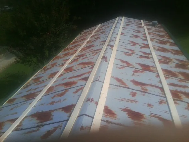 Rusted metal roof panels with new wood purlins before replacement — Storm Damage Roof Repair in Kodak by Roofing Brothers