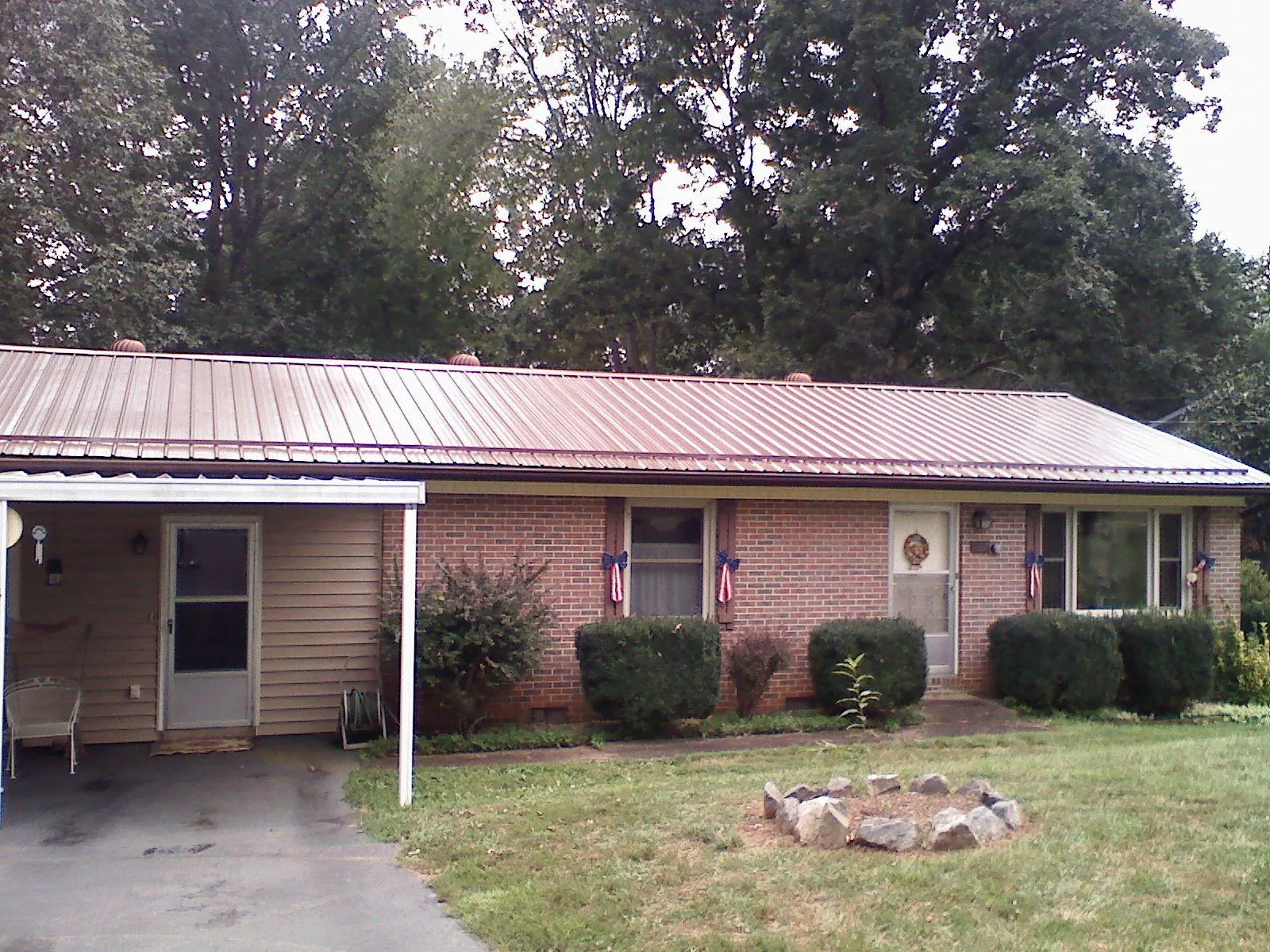 Bronze metal roof and carport on a brick ranch home — Roof Repair work by our crew in Kodak